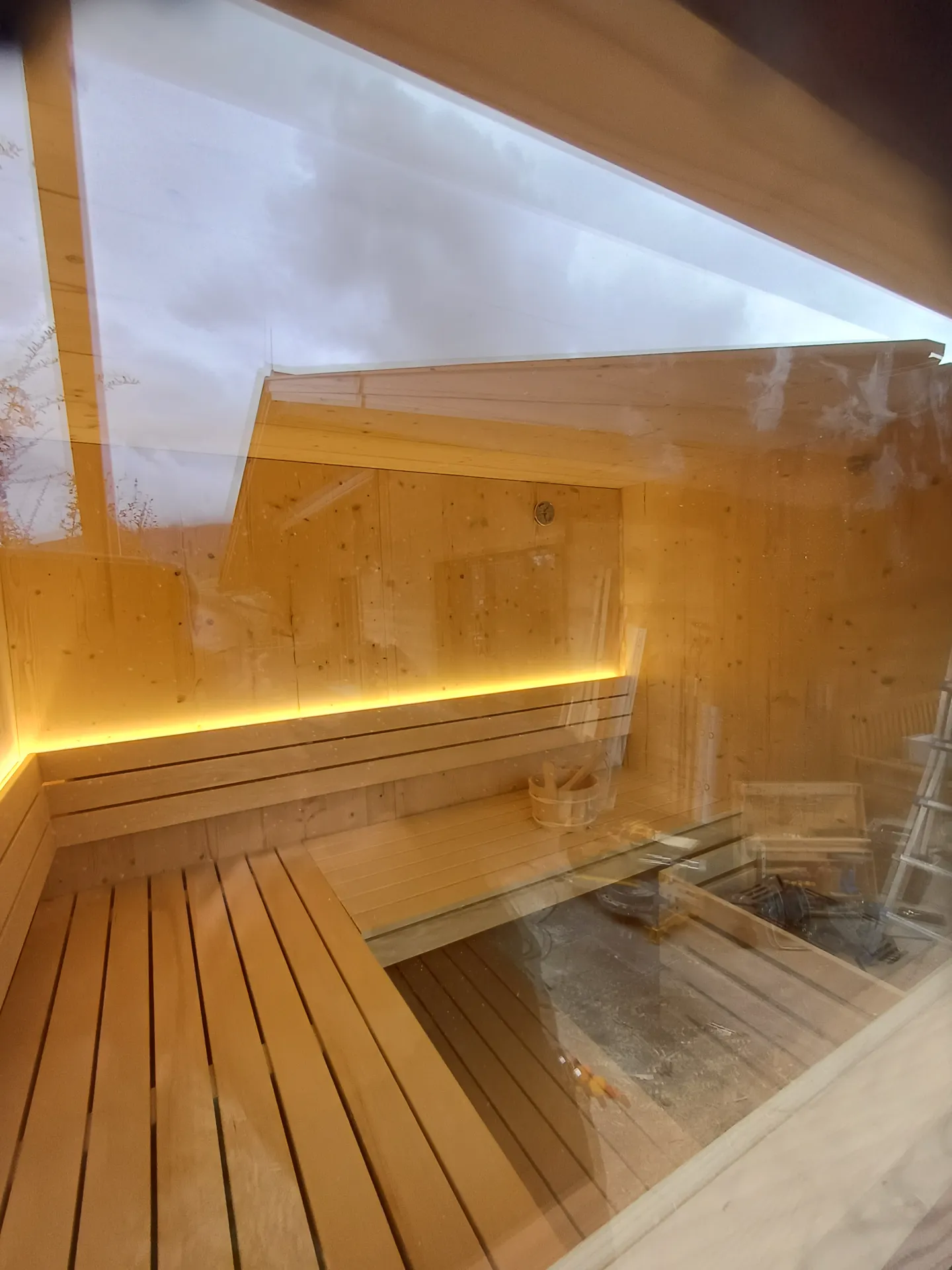 Blick durch das Fenster in die beleuchtete Außensauna